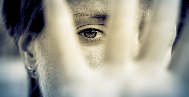 Woman holding up a hand in fear