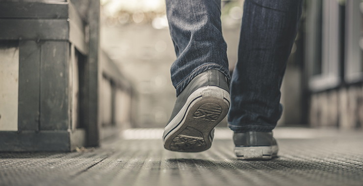 young person walking in jeans and sneakers
