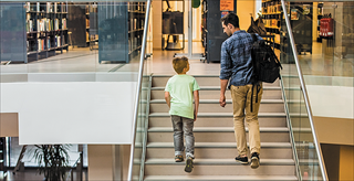 Man and boy walking up library steps