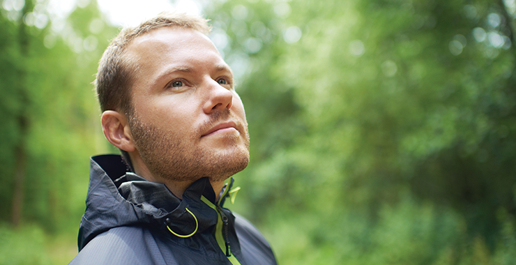 man outside staring toward tree