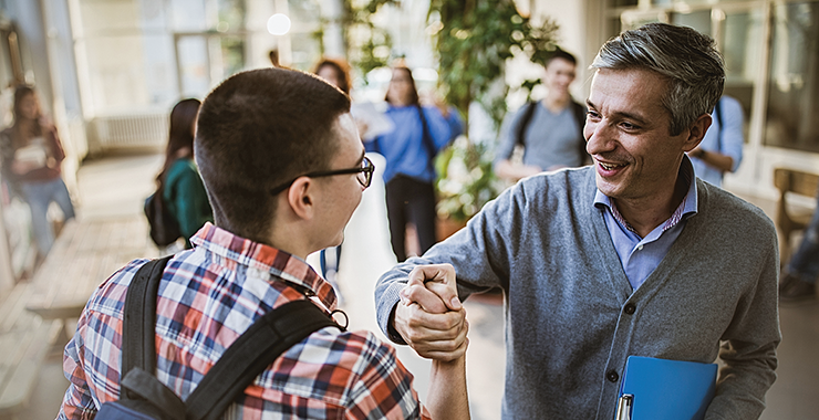 Teacher giving a student a handshake