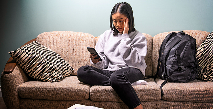 Woman holding a cell phone looking pensive
