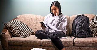 Woman holding a cell phone looking pensive