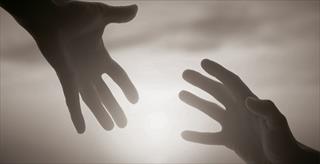two outstretched hands reaching toward each other