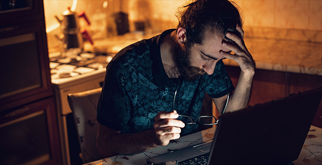 man looking distress while sitting in front of a laptop