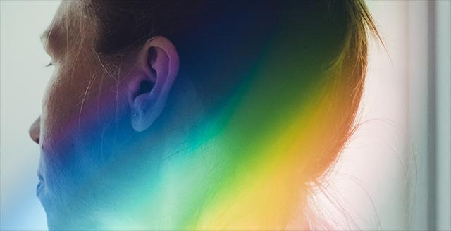 profile of a person with a rainbow reflecting on their head