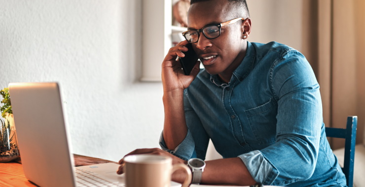 Man talking on a cellphone and using a laptop