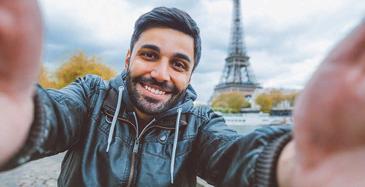 man taking a selfie in front of the Eifel Tower
