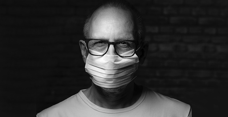 older man with glasses wearing a non-medical mask