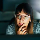 woman listening to a conversation in front of a laptop