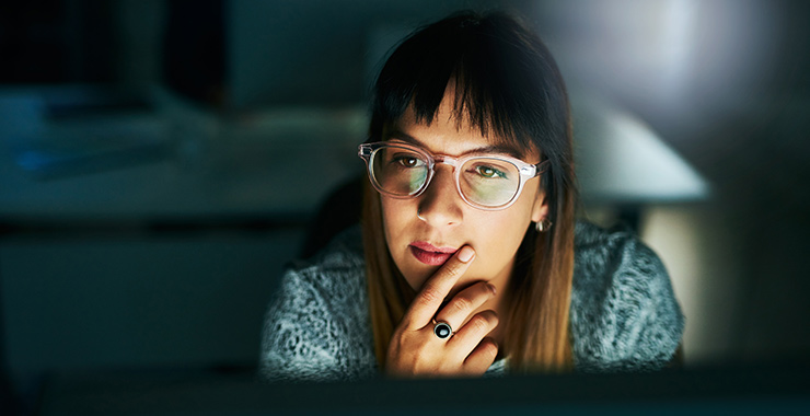 pensive looking woman in front of a laptop