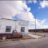 old building with pick up truck parked next to it