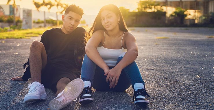 two young people sitting on the ground
