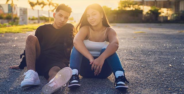 two young people sitting on the ground
