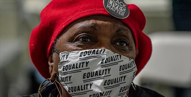 woman of color wearing a mask and BLM pin