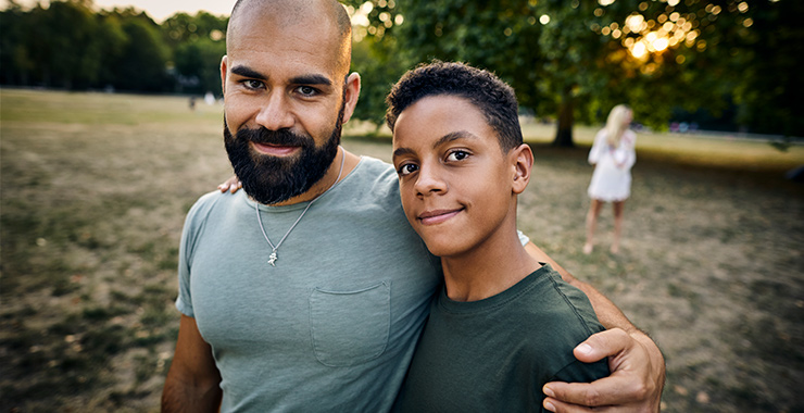 man and teen with arms around shoulders