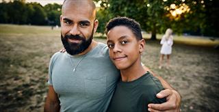 man and teen with arms around shoulders