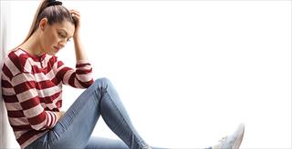 teen sitting on the floor looking upset