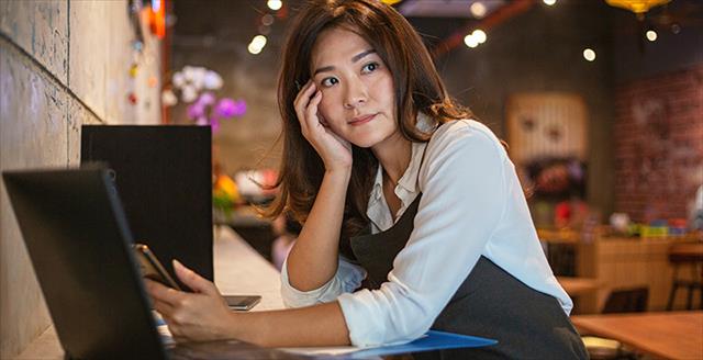 young woman in front of a computer looking worried
