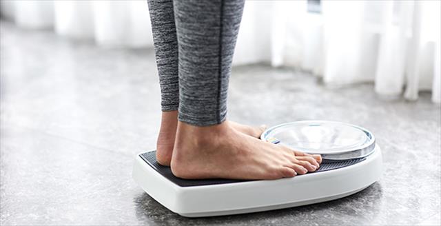 person standing on a bathroom scale