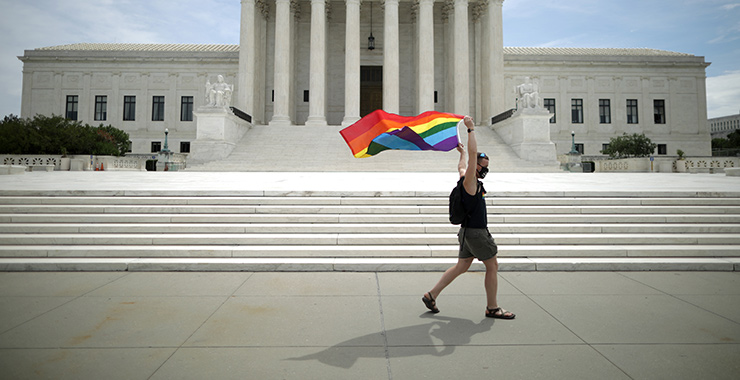 An LGBTQ+ advocate walks by the U.S. Supreme Court