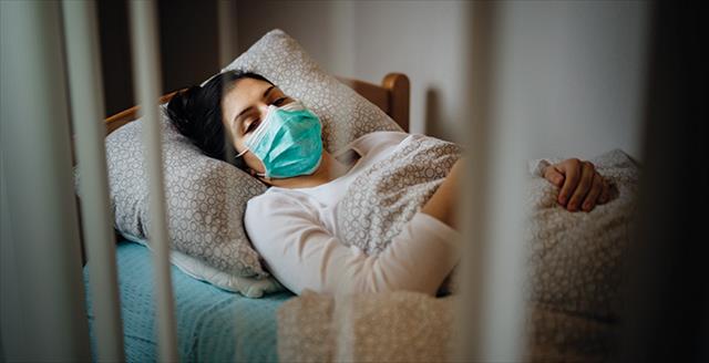 woman in bed wearing a nonmedical mask