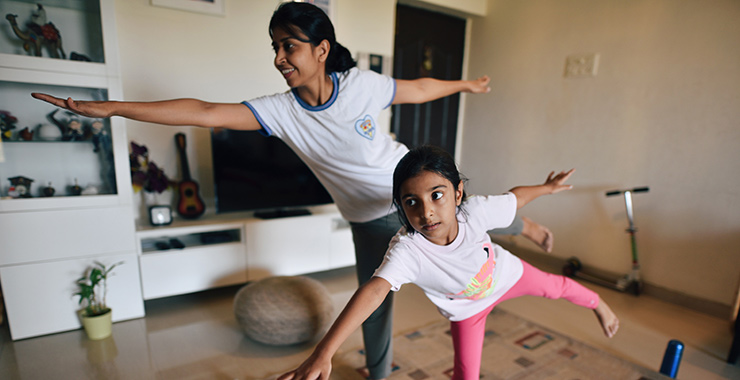 mother and young daughter doing yoga together