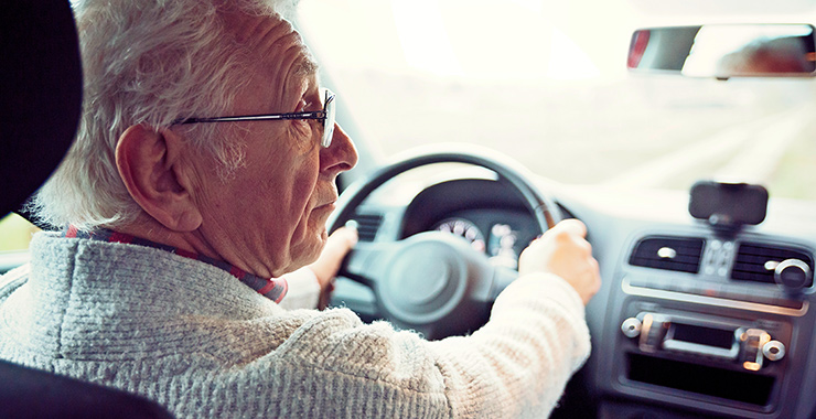 elderly man driving a car