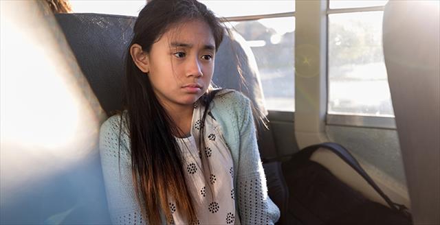 girl sitting by herself on a bus