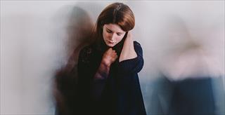 woman looking sad sitting on the floor