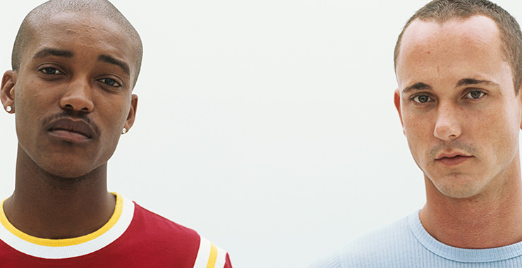 a couple of men staring straight ahead and standing apart