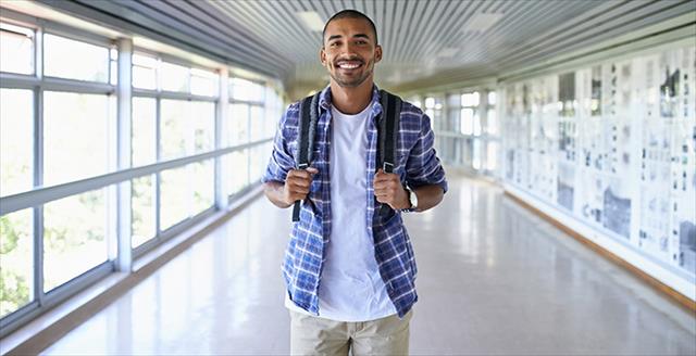 young adult wearing a school book backpack