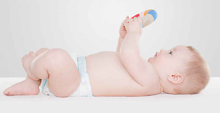 baby on its back looking at a toy