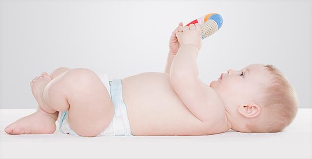 baby on its back looking at a toy
