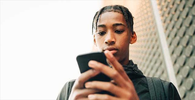 young man engrossed in an activity on his smart phone