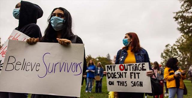women holding banners in support of sexual assault victims