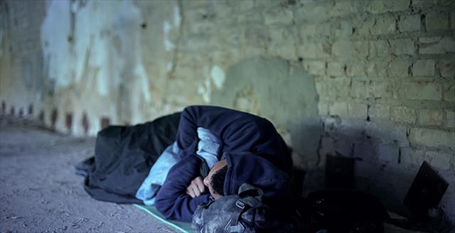 homeless person sleeping outside on the ground