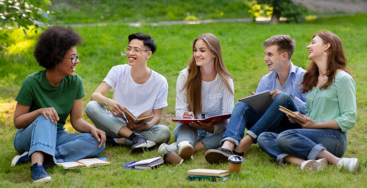 college students sitting outside studying