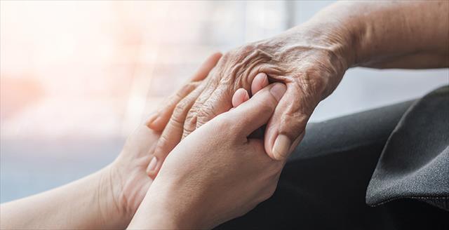 young hands holding the hands of an older person