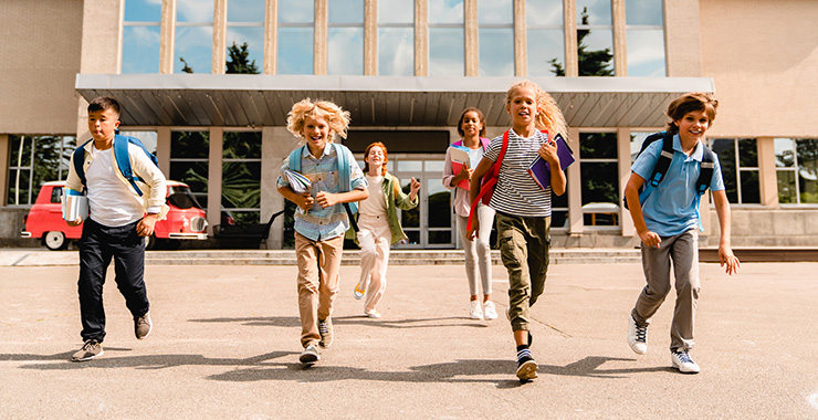 happy kids running from school building