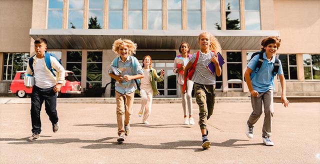 happy kids running from school building