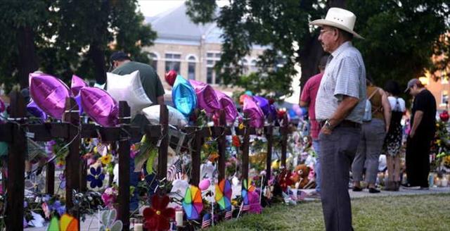 man standing in front of a makeshift memorial