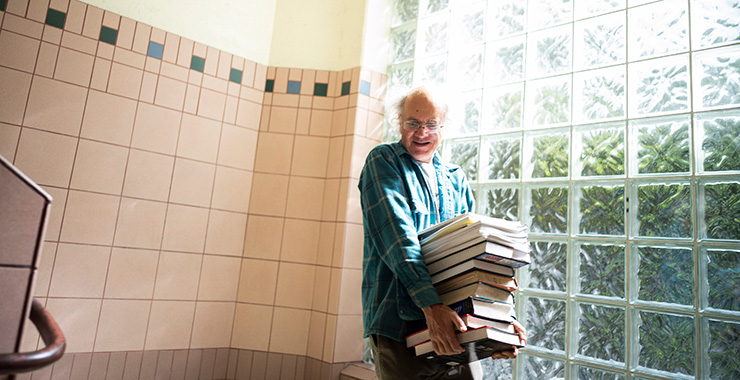 educator holding a stack of books