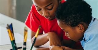 two young boys working on a project together