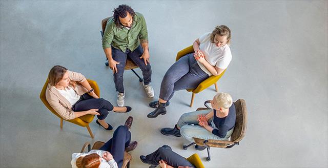 circle of people sitting in chairs