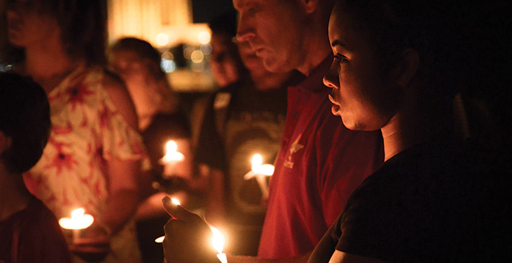 group of people holding candles at a night vigil