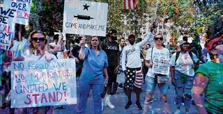 protestors with signs against vaccination