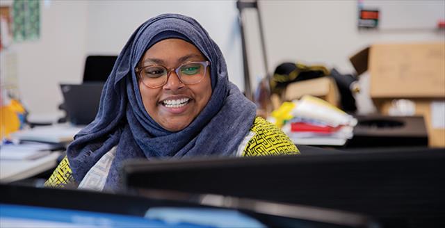smiling woman wearing a headscarf and glasses