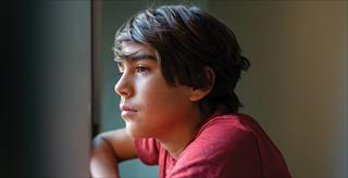 tween boy looking out a window