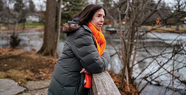 adult woman outside leaning on a wood fence